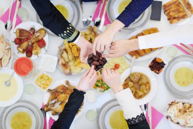 Mübarek Mübarek ailesi ziyafeti kırmak için akşam yemeği yiyor. Ramazan Bayramı 'nda evde geleneksel yemekler yemek. Modern Batı İslam 'da İslami Helal Yeme ve İçme