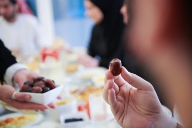 Mübarek Mübarek ailesi ziyafeti kırmak için akşam yemeği yiyor. Ramazan Bayramı 'nda evde geleneksel yemekler yemek. Modern Batı İslam 'da İslami helal yiyecekler ve içecekler.