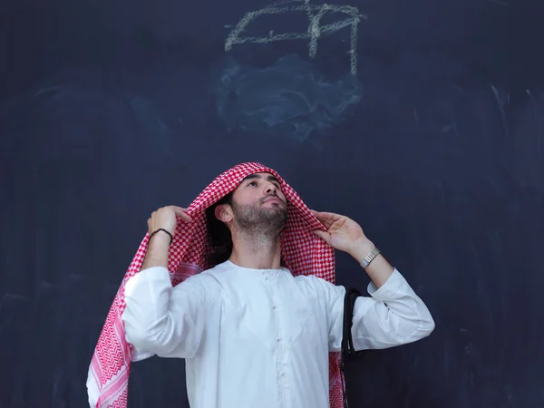 現代のイスラムファッションとラマダーンカレームの概念を表す黒い黒板の前に伝統的な服の若いアラビア人の男の肖像画 — ストック写真