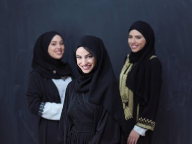 Modern İslami modayı ve Ramazan Kareem kavramını temsil eden siyah tesettürlü şık giyinmiş güzel Müslüman kadınların grup portresi.