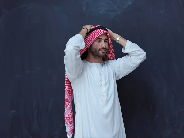 現代のイスラムファッションとラマダーンカレームの概念を表す黒い黒板の前に伝統的な服の若いアラビア人の男の肖像画 — ストック写真