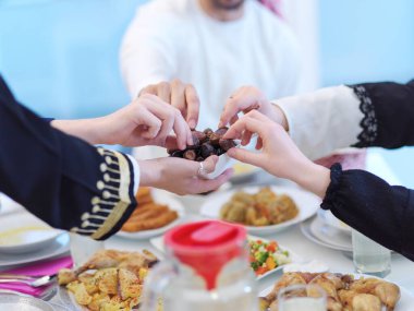 Mübarek Mübarek ailesi ziyafeti kırmak için akşam yemeği yiyor. Ramazan Bayramı 'nda evde geleneksel yemekler yemek. Modern Batı İslam 'da İslami helal yiyecekler ve içecekler.