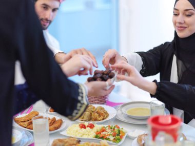Mübarek Mübarek ailesi ziyafeti kırmak için akşam yemeği yiyor. Ramazan Bayramı 'nda evde geleneksel yemekler yemek. Modern Batı İslam 'da İslami helal yiyecekler ve içecekler.