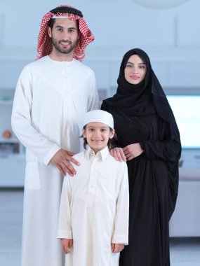 Geleneksel giysiler içinde oğlu olan mutlu Arap aile fertlerinin portresi Ramazan ayı boyunca evde birlikte vakit geçiriyorlar.