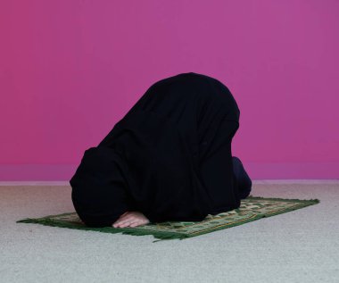 Allah için dua eden Müslüman bir kadın. Müslüman kadın halıda geleneksel ortadoğu kıyafetleri içinde dua ediyor, tesettürlü kadın.