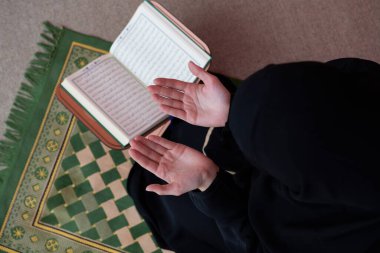 Orta Doğulu bir kadın, Kuran 'ı namaz kılar ve okur. Müslüman bir kadının ramazan ayında evde ya da camide Kuran okuması..