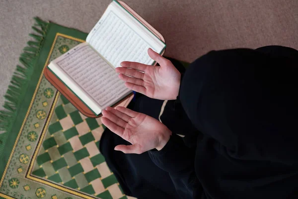 中東の女性は聖クルアーン 全ムスリムの公用品 を祈り 読んでいます ムスリム女性の教育概念 ラマダーン月の家庭やモスクでの聖クルアーン — ストック写真