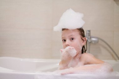 Coronavirus sırasında sabun köpüğüyle oynayan küçük kız evde kalıp karantina altında kalıyor.