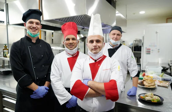 요리사들의 초상화가 코로나 바이러스에서 마스크와 장갑을 착용하고 식당에서 — 스톡 사진
