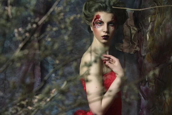 Femme en robe rouge. Coiffure fantastique et maquillage . — Photo