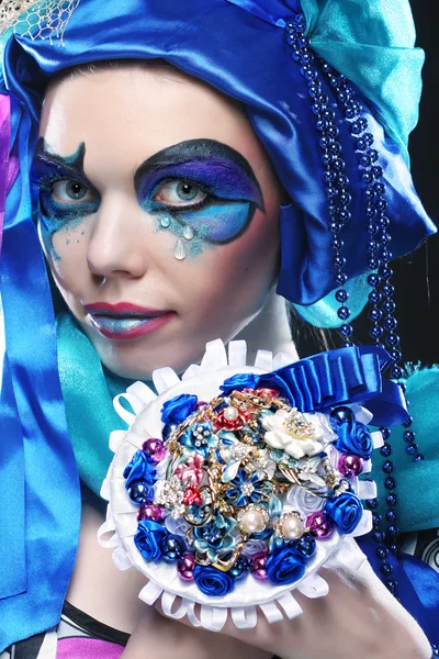 Woman with creative make up holding a bouquet of jewelry — Stock Photo, Image