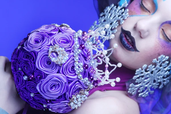 Mujer con maquillaje creativo sosteniendo un ramo de joyas —  Fotos de Stock