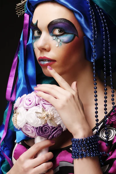 Frau mit kreativem Make-up hält einen Strauß Schmuck in der Hand — Stockfoto