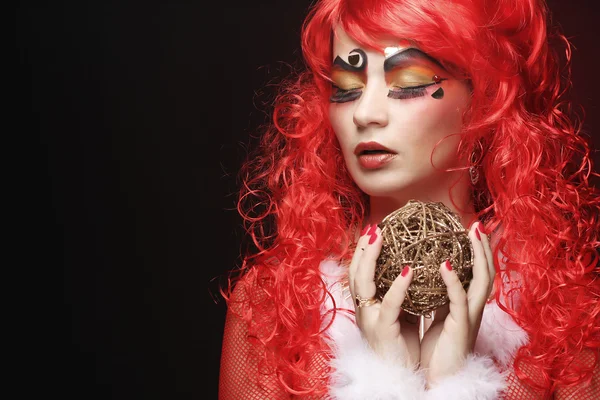 Mooie dame met artistieke make-up holding kerst decoratie — Stockfoto
