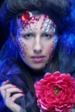 sanatsal visage büyük kırmızı çiçek tutan genç kadınla