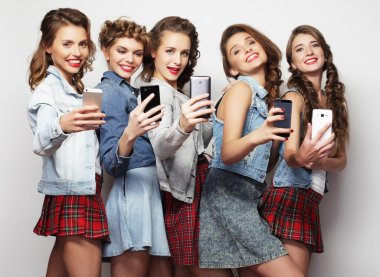 Grup genç kadını kendi smartphones vasıl arıyorsunuz