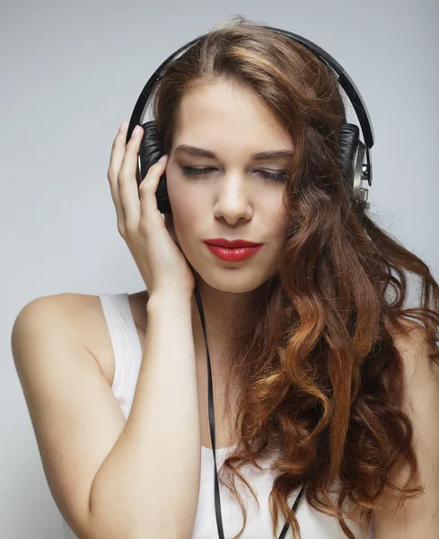 Mujer joven con auriculares escuchando música — Foto de Stock