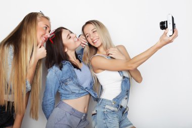 Mutlu kız arkadaşlar kamerayla fotoğraf çekiyorlar.