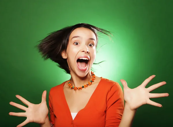 Junge Frau überrascht über grünen Hintergrund — Stockfoto
