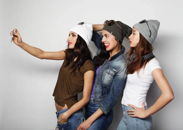 Adolescentes niñas amigos en hipster traje hacer selfie en un teléfono —  Fotos de Stock