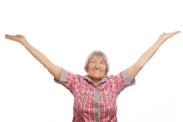 Allegra donna anziana gesticolare vittoria su uno sfondo bianco — Foto Stock