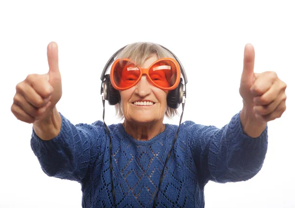 Funny old lady listening music and showing thumbs up. — Stock Photo, Image