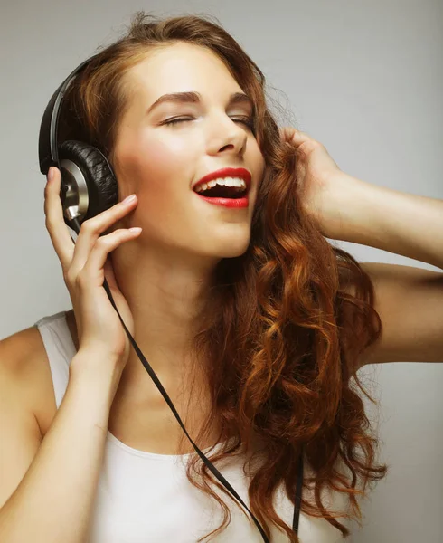 Νεαρή γυναίκα με ακουστικά που ακούει μουσική — Φωτογραφία Αρχείου