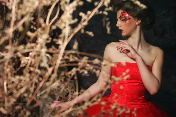 Mujer vestida de rojo. Fantástico peinado y maquillaje . — Foto de Stock