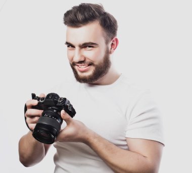 Genç sakallı fotoğrafçı dijital kamerayla fotoğraf çekiyor..