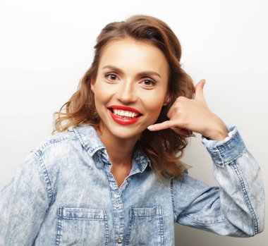 Gündelik kıyafetler giyen genç ve güzel bir kadın.