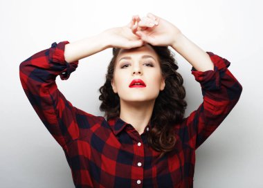 Gündelik kıyafetler giyen genç ve güzel bir kadın.