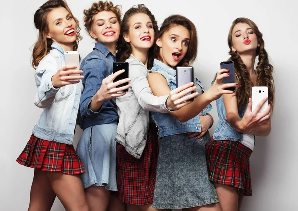 Grupo de mujeres jóvenes mirando a sus teléfonos inteligentes — Foto de Stock