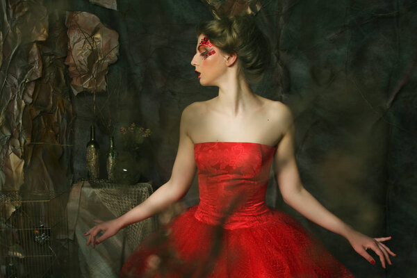 Fairy Tale. Theatre. Woman in red dress. Fantastic Hairstyle and make up. Fantasy.