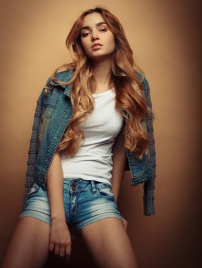 Genç güzel kıvırcık kadın sarı arka plan üzerinde poz