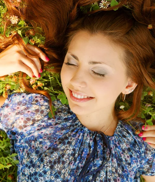 Mooi meisje legt op een gras — Stockfoto