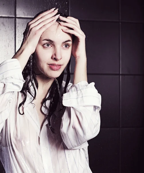 Girl under a shower on black — Stockfoto