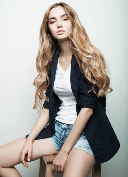 Yaşam tarzı, moda ve insan konsepti: güzel kadın günlük kıyafetler giyiyor, beyaz arka planda poz veriyor.