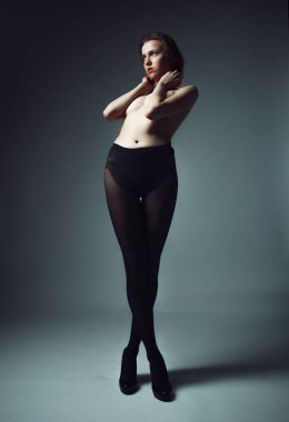 Siyah külotlu çorap giyen kısa sarı saçlı bir manken.