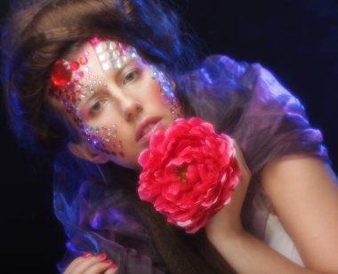 sanatsal visage büyük kırmızı çiçek tutan genç kadınla