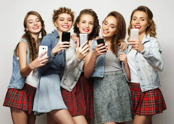 Groupe de jeunes femmes regardant leurs smartphones — Photo