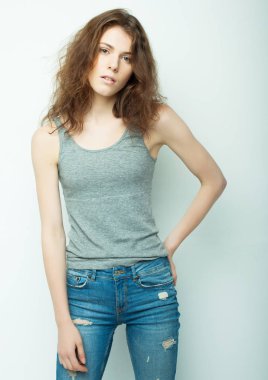 Genç, güzel kıvırcık kadın beyaz arka planda poz veriyor.