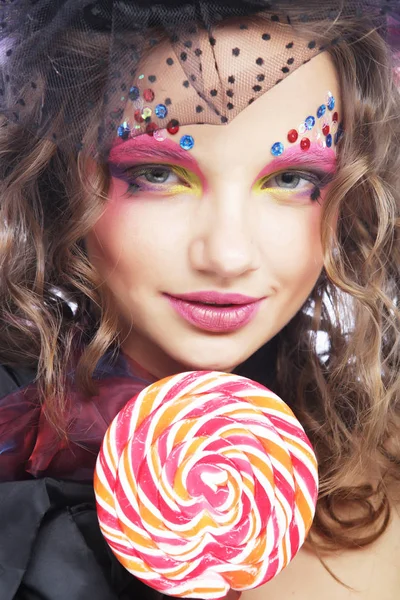 Girl with with creative make-up holds lollipop. — Stock Photo, Image