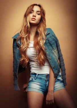 Stüdyoda sarı arka planda poz veren güzel elbiseli manken.