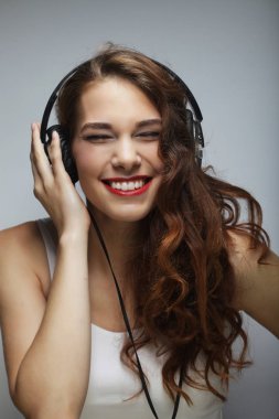 Kulaklıklı genç bir kadın müzik dinliyor.