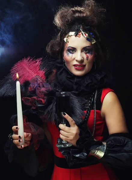 Young woman wearing carnival costume holding a candle. — Stock Photo, Image
