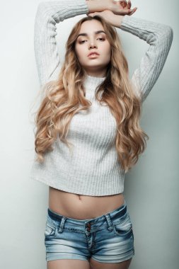 Genç, güzel kıvırcık kadın beyaz arka planda poz veriyor.