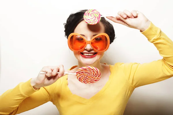 Mujer usando gafas de sol grandes sosteniendo piruleta — Foto de Stock