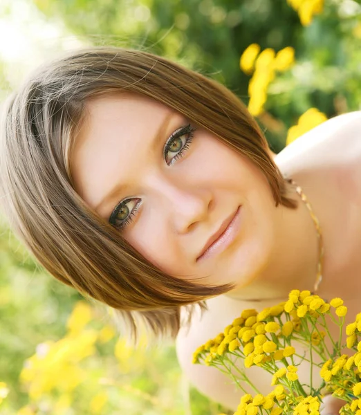 Młoda kobieta i dzikie kwiaty. — Zdjęcie stockowe