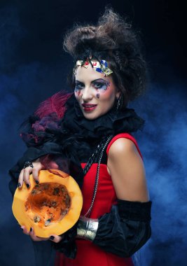 Kabak koyu arka plan üzerinde tutan genç güzel cadı