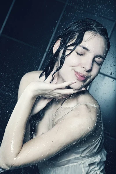 Girl under a shower on black — Stockfoto